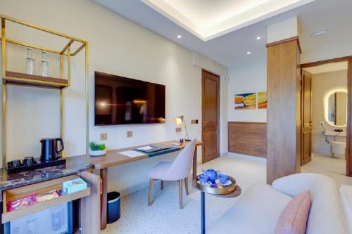 a living room with a couch and a desk in a room at The Manor - New Delhi in New Delhi
