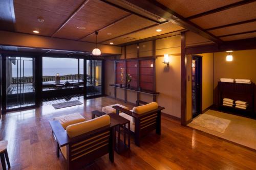 a living room with furniture and a view of the ocean at Bousui in Higashiizu