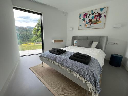 a bedroom with a bed and a large window at Casa Calmavista in Paços de Gaiolo