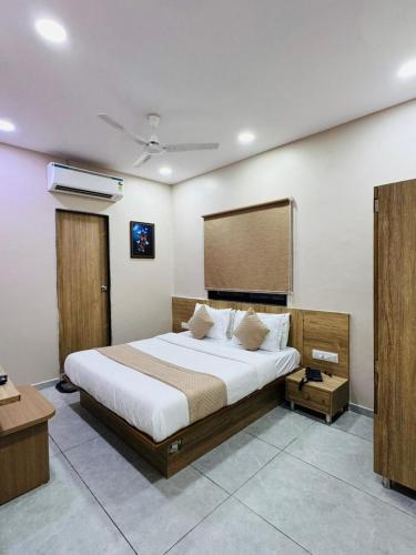 a bedroom with a large bed in a room at Hotel Captown Inn in Ahmedabad