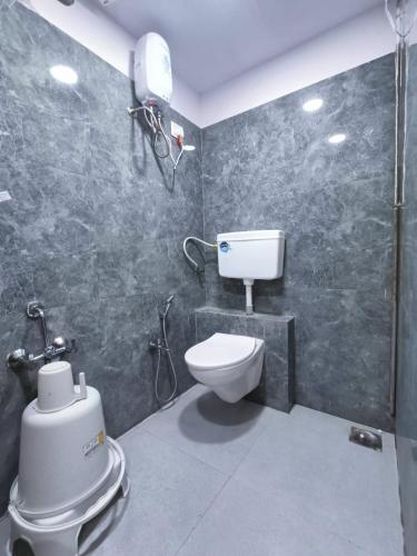 a bathroom with a toilet and a shower in it at Hotel Captown Inn in Ahmedabad