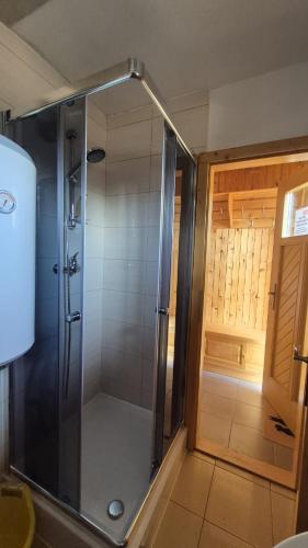a shower with a glass door in a bathroom at Chata DIANA - Kraviarky in Liptovský Ján