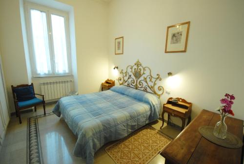 ローマにあるCasa Anna a Romaのベッドルーム1室(青い毛布、テーブル付)