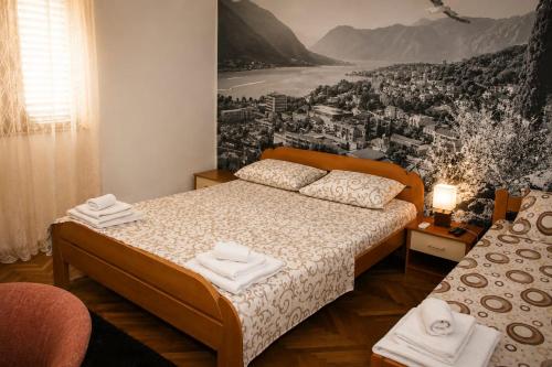 a bedroom with a bed with a painting on the wall at Apartman Jadran Private Parking in Dobrota