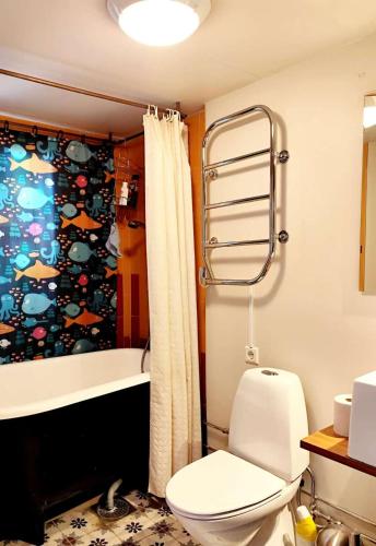 a bathroom with a toilet and a shower curtain at Station Villa Vimmerby in Vimmerby