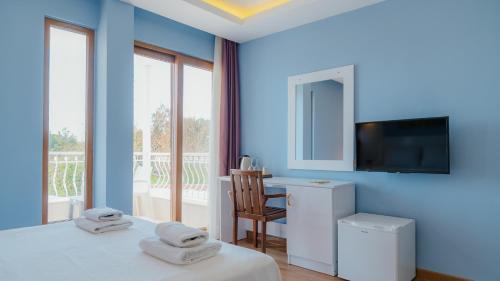 a blue room with two beds and a desk and a television at Hotel No37 in Kaş