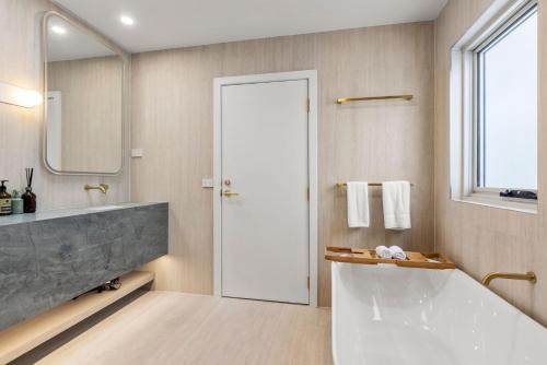 a bathroom with a large tub and a large mirror at Casa Bianca - Fireplace with Swimming Pool in Callala Beach
