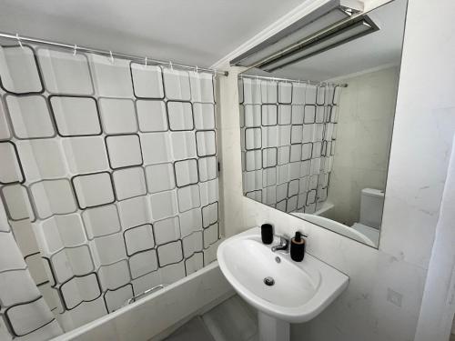 a white bathroom with a sink and a mirror at Elenas sweet home - Penthouse with Large Balcony in Pyrgos