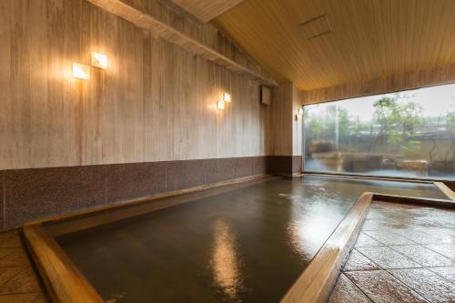 a swimming pool in a room with a large window at Bousui in Higashiizu