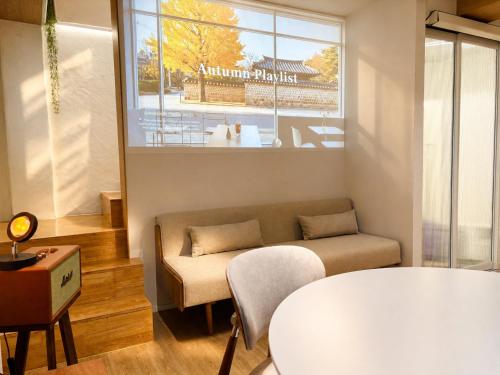 a living room with a couch and a window at Moonraejung Hostel in Seoul
