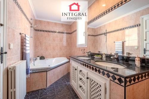 a bathroom with a tub and a sink and a bath tub at Casa Aiguamarina in Palamós