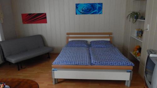 ein kleines Schlafzimmer mit einem Bett und einem Stuhl in der Unterkunft Pension Königlich Schlafen in Coswig