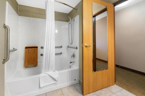 a bathroom with a tub and a shower with a mirror at Comfort Inn Iron Mountain North in Iron Mountain
