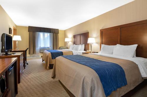 a hotel room with two beds and a flat screen tv at Comfort Inn Iron Mountain North in Iron Mountain