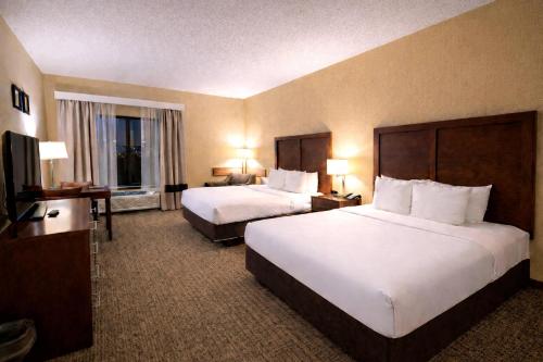 a hotel room with two beds and a flat screen tv at Comfort Inn Owatonna near Medical Center in Owatonna
