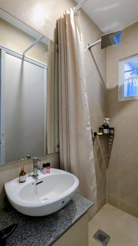 a white sink in a bathroom with a shower at Cityloft Bungalow in Dauis