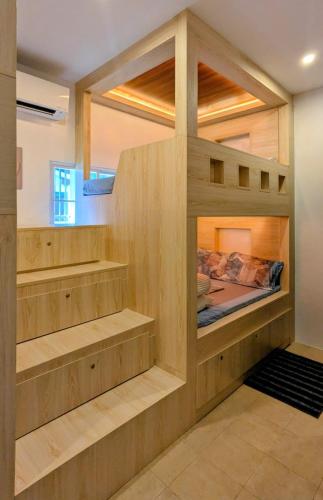 a room with a bunk bed with wooden shelves at Cityloft Bungalow in Dauis