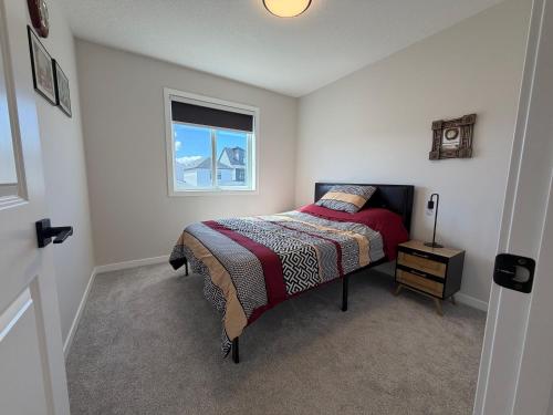 a bedroom with a bed and a window at Beautiful New House in Alpine Park, Calgary in Calgary