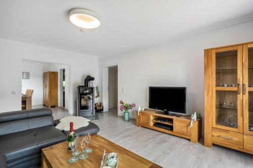 a living room with a couch and a flat screen tv at Ferienwohnung Sauerland an der Ruhr in Olsberg