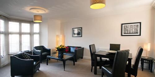 a living room with a table and chairs at Victoria Mansions Hotel Apartments in Weston-super-Mare