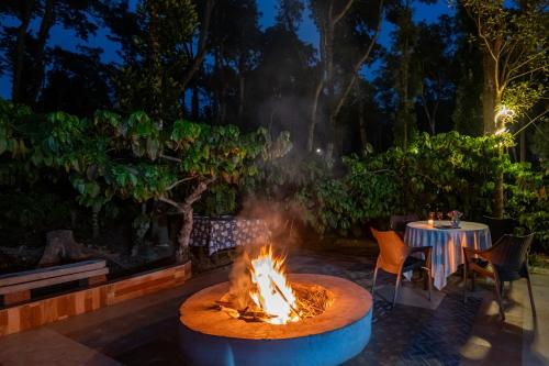 a fire pit in the middle of a patio at night at Avocado Cottages by Alaya Stays, Coorg in Suntikoppa