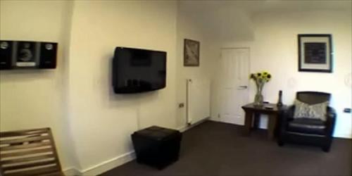 a living room with a flat screen tv on the wall at Victoria Mansions Hotel Apartments in Weston-super-Mare