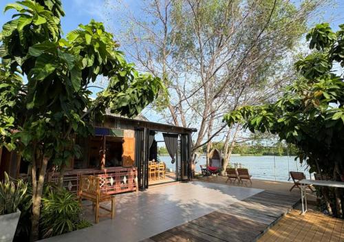 ein Haus am Wasser mit Terrasse in der Unterkunft Amphawa Hideaway in Amphawa