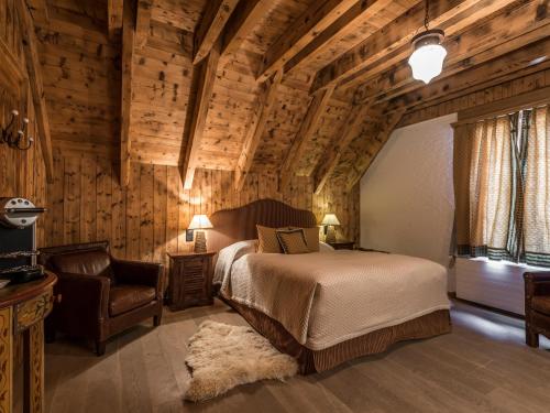 a bedroom with a bed and a chair at Alpenclub in Engelberg