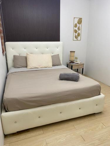 a bed with a white bed frame in a room at As Thetic Transient in San Pablo