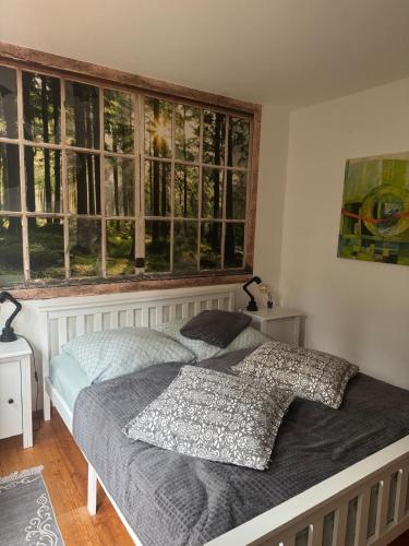 a bedroom with a bed and a large window at Herzenslicht in Ingenried