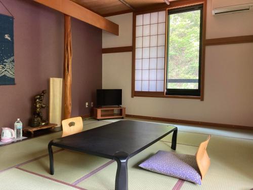 a living room with a black table and chairs at Takaragawa Onsen Ousenkaku in Minakami