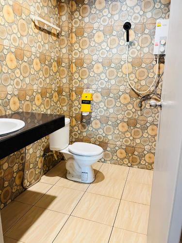a bathroom with a toilet and a stone wall at Baan Archa Samui in Bophut