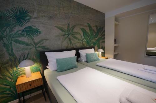 a bedroom with two beds with a tropical wallpaper at Pension Dortmund Messe in Dortmund