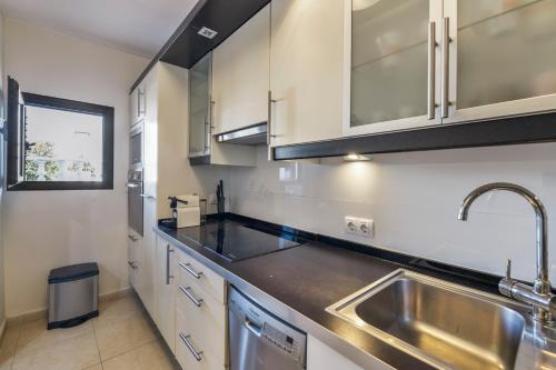 a kitchen with white cabinets and a sink at Casa Emma in Playa Honda