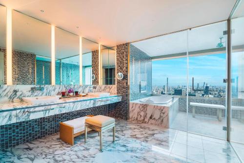 a bathroom with two sinks and a tub and a window at The Prince Gallery Tokyo Kioicho, a Luxury Collection Hotel in Tokyo