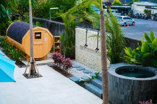 a backyard with a dog house and a palm tree at Watermark Hotel & Spa Bali in Jimbaran