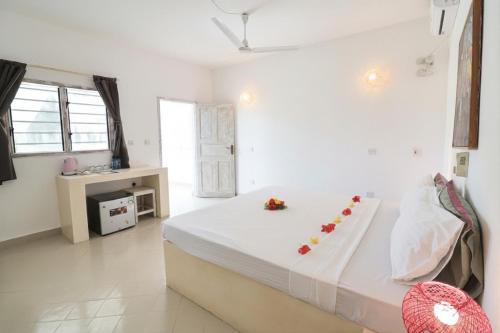 a bedroom with a large bed with flowers on it at Ascot Watamu Resort in Watamu