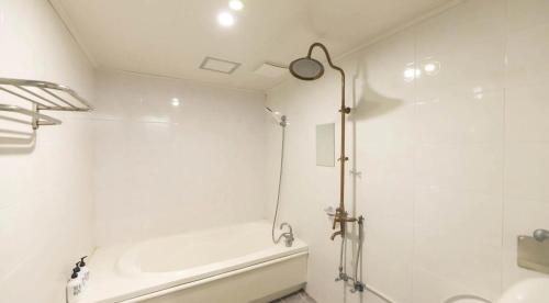 a bathroom with a shower and a sink and a tub at 747 Motel in Gimcheon