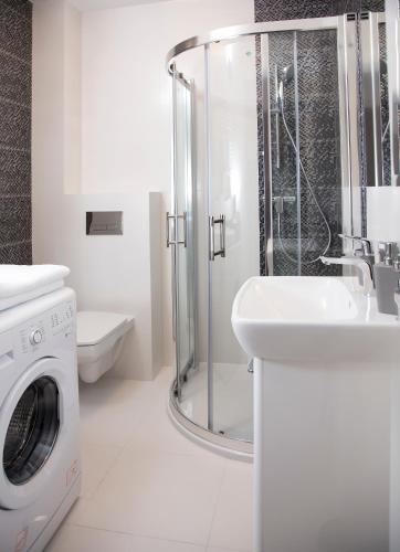 a white bathroom with a washing machine and a sink at 100-SIO Apartamenty in Koszalin