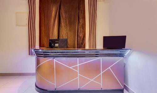 a glass counter with a laptop on top of it at Itsy Hotels Dew Dreams in Cochin