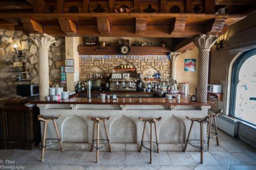 a bar in a restaurant with two stools at Hostal Restaurante El Castillo in Olmillos de Sasamón