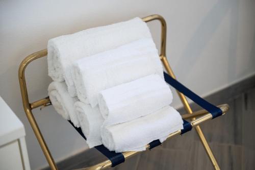 a stack of towels on a towel rack in a bathroom at Moon - Rooms in Quartu SantʼElena