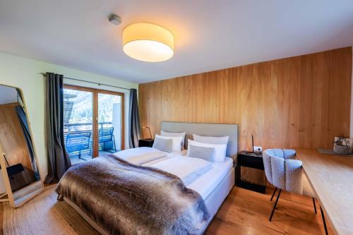 a bedroom with a bed and a desk and a window at Loft7 in Mittelberg