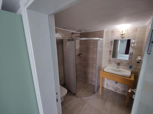 a bathroom with a shower and a sink and a toilet at Datça Stayinn Otel in Datca