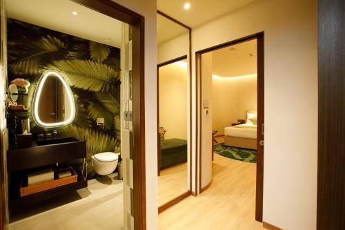 a bathroom with a toilet and a mirror at 080 Transit Hotel, T2 in Bangalore