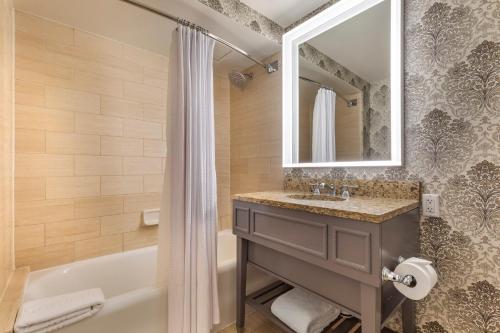 a bathroom with a tub and a sink and a mirror at Omni Shoreham Hotel Washington DC in Washington, D.C.