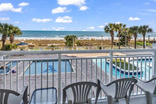 a balcony with chairs and a view of the beach at Hosteeva Atlantica Oceanfront Condo in Myrtle Beach