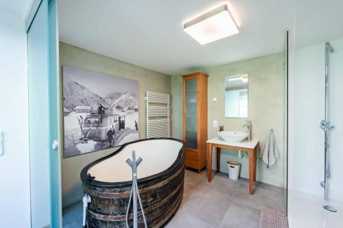 a bathroom with a tub in the middle of a room at Loft7 in Mittelberg