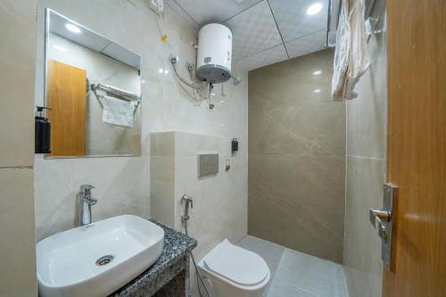a bathroom with a sink and a toilet and a shower at Krishna Abode by Perfect Stayz near Prem Mandir with Parking in Vrindāvan