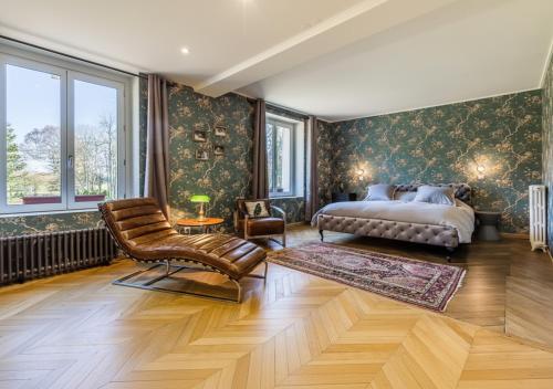 a bedroom with a bed and a chair at Chateau Leken's in Saint Germain la Campagne